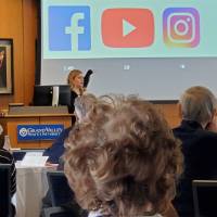A woman points to a presentation with social media icons displayed